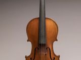 un vieux violon posé sur une surface blanche