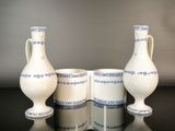 three white and blue vases sitting on a black table
