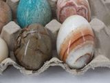 six eggs in a carton with marbles in them