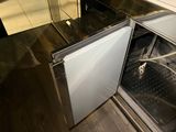 a small refrigerator that is open in the kitchen