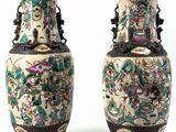 pair of chinese vases with figures on them against a white background