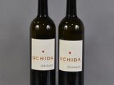 deux bouteilles de vin posées sur une table l'une à côté de l'autre