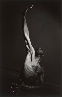 a black and white photo of a man with his arms in the air