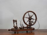 un rouet en bois posé sur une table, avec des bougies