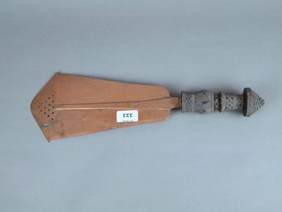 une spatule en bois avec un manche en métal posée sur une surface grise