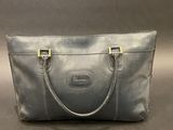 a grey leather handbag with gold handles on a gray background