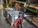 a dolly truck with a container on it in a warehouse