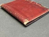 leather wallet with a brown leather cover on a gray surface