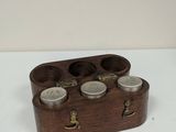 a small wooden box with four jars in it
