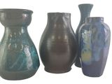 trois vases posés l'un à côté de l'autre sur une surface blanche