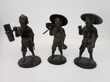 trois figurines en bronze représentant des hommes asiatiques portant des chapeaux et des armes