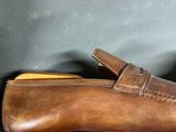 tan leather loafer shoes with brown soles on a gray surface