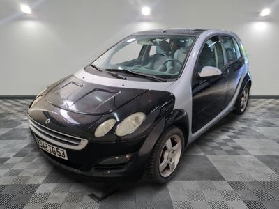 une petite voiture noire et blanche garée sur un sol à damier