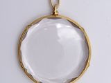 an image of a gold plated pendant with a clear glass in the center