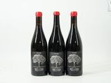 trois bouteilles de vin posées sur une table blanche