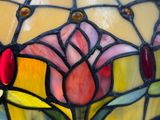 un gros plan d'un vase en vitrail orné de fleurs