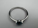 a close up of a ring with a blue stone in it