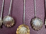 six silver spoons and spoon spoons with shells on them