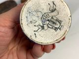a person holding a small bowl with a drawing on it