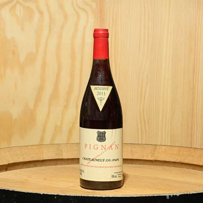 une bouteille de vin posée sur un tonneau en bois