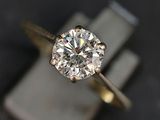 un gros plan d'une bague en diamant posée sur un bloc de marbre