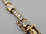 a close up of a gold bracelet with diamonds on it