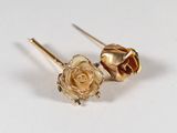 pair of gold tone flower earrings with green crystals on white background