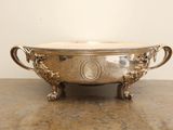a silver bowl on a table with a handle on it