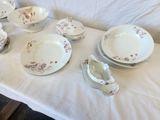 a white table with a bunch of plates and bowls on it