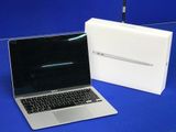 a laptop computer sitting next to a box on a blue surface