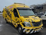 yellow van with flames painted on it parked in a parking lot