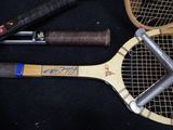 two tennis rackets and a bat on a black surface