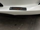 a close up of a white car with a sticker on it ' s bumper