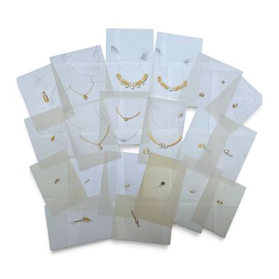 a lot of white bags with gold necklaces on them