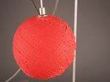 a red ball of yarn hanging from a wire