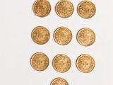 a close up of a bunch of gold coins on a white surface