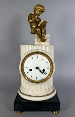 une petite statue représentant un garçon assis sur le cadran d'une horloge
