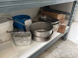 many pots and pans on a shelf in the kitchen