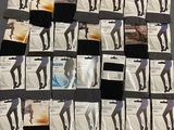 several pairs of women ' s black and white tights on a bed