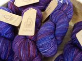 purple and blue yarn in a bowl with tags on them