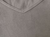 a close up of the back of a gray shirt with a small patch on it