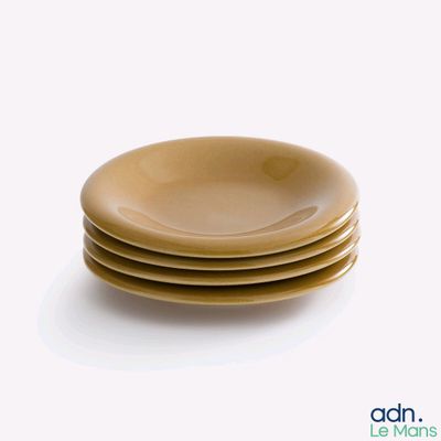 quatre assiettes empilées les unes sur les autres sur une surface blanche
