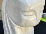 a white sculpture of a face on a black table