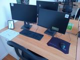 two computer monitors on a desk with a keyboard and mouse