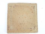 a square piece of clay on a white surface