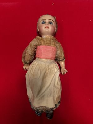 an old doll is laying on a red surface with a red background