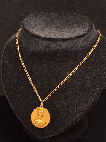 Chaine de cou et pendentif rond à décor d’un profil féminin en or...