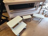 trois tables blanches et deux tabourets posés à même le sol