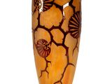 a vase that has shells on it on a stand