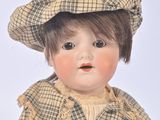 a doll that is sitting on the ground wearing a hat